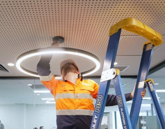 commercial electrician installing pendant light